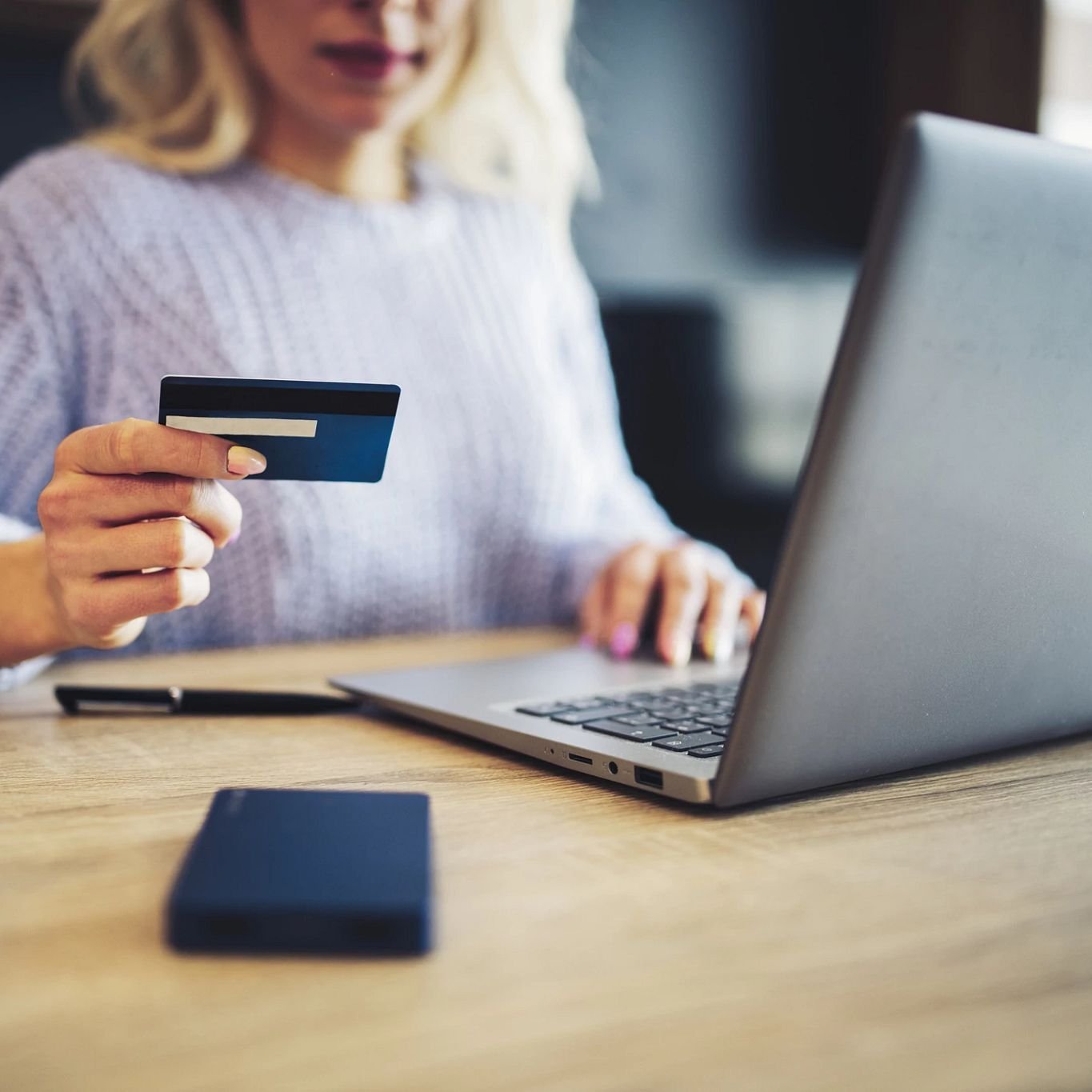 Person using laptop to pay online by card - Fast and easy financing with approved credit via Wells Fargo from Flooring Source in the Auburn, MA area