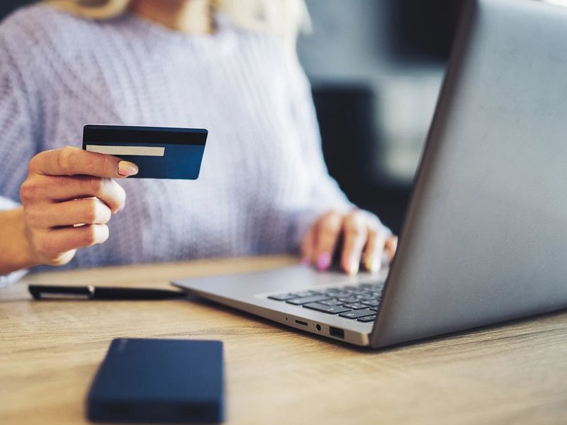 Person using laptop to pay online by card - Fast and easy financing with approved credit via Wells Fargo from Flooring Source in the Auburn, MA area