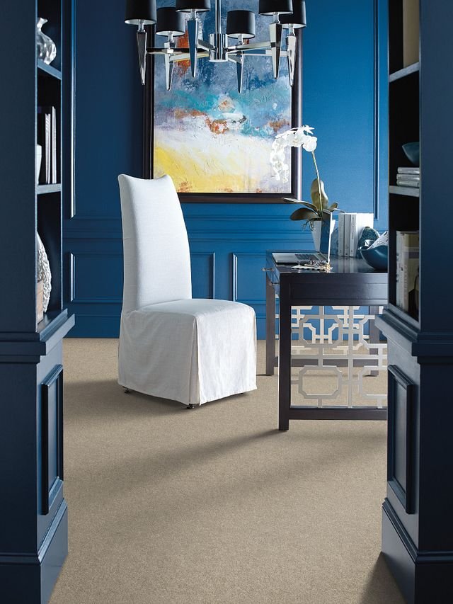 Modern home office with a white chair and black desk on beige carpet from Flooring Source in the Auburn, MA area