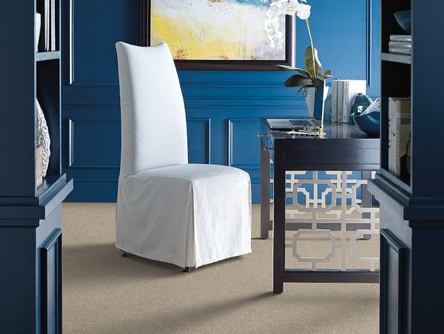 Modern home office with a white chair and black desk on beige carpet from Flooring Source in the Auburn, MA area